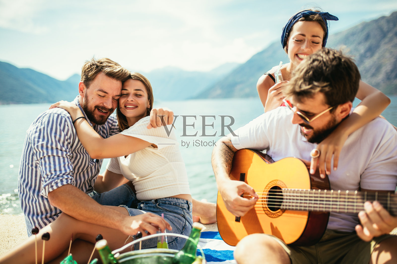 年轻人正在玩暑假。快乐的朋友们在海滩上喝着热带鸡尾酒。照片摄影图片