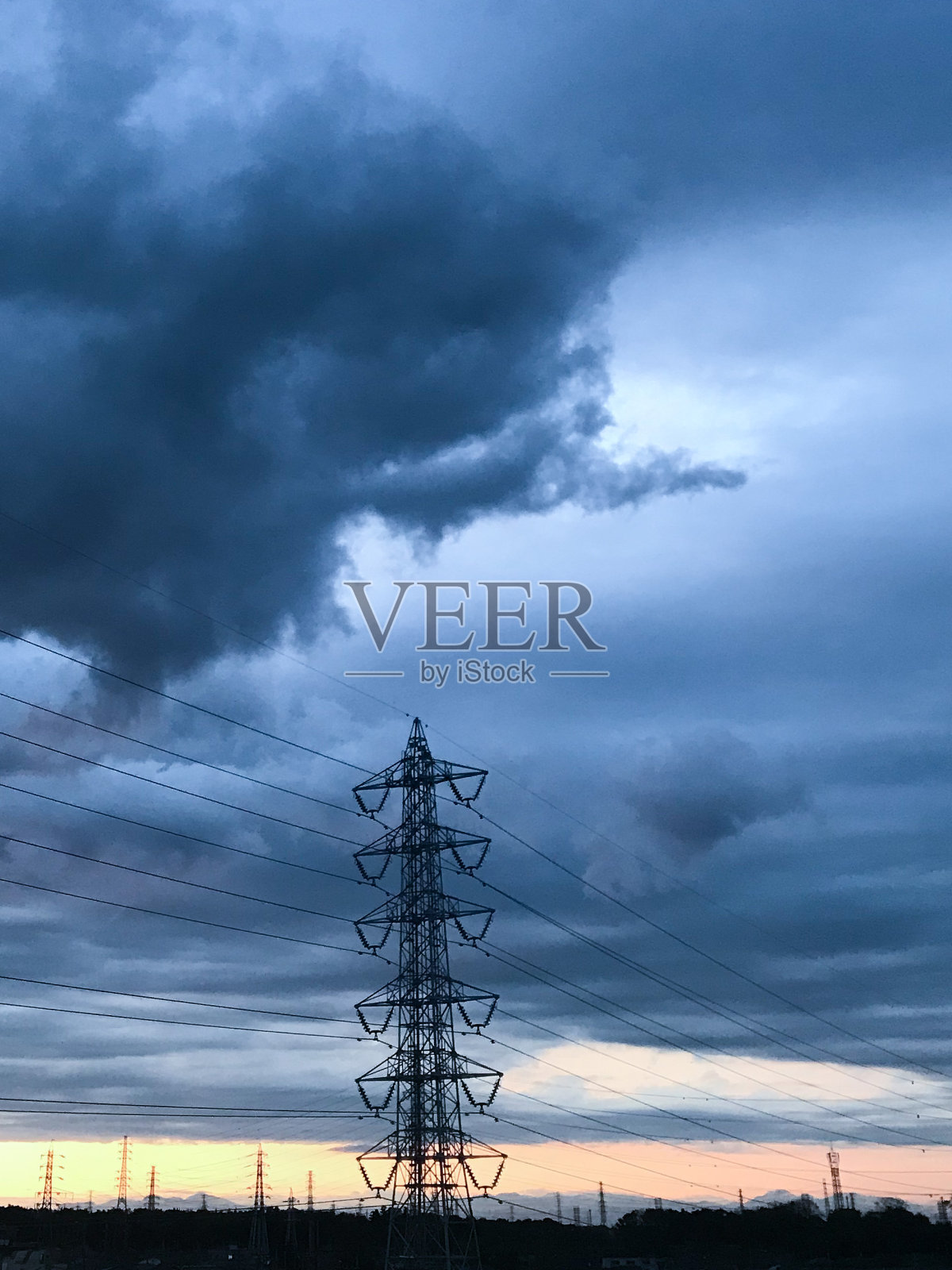 黄昏时分的高压电线和高塔。照片摄影图片