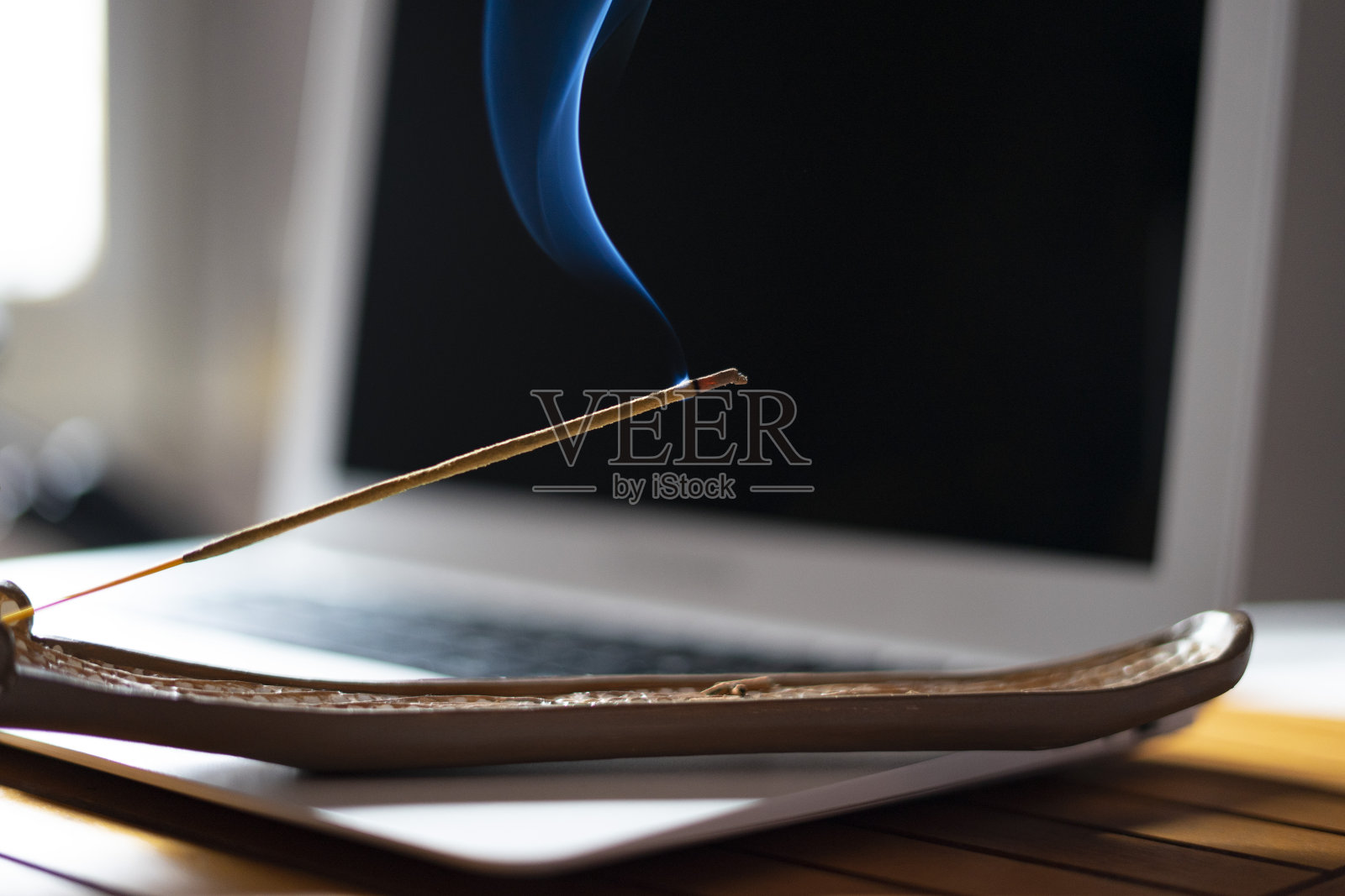 电脑旁点着香。照片摄影图片