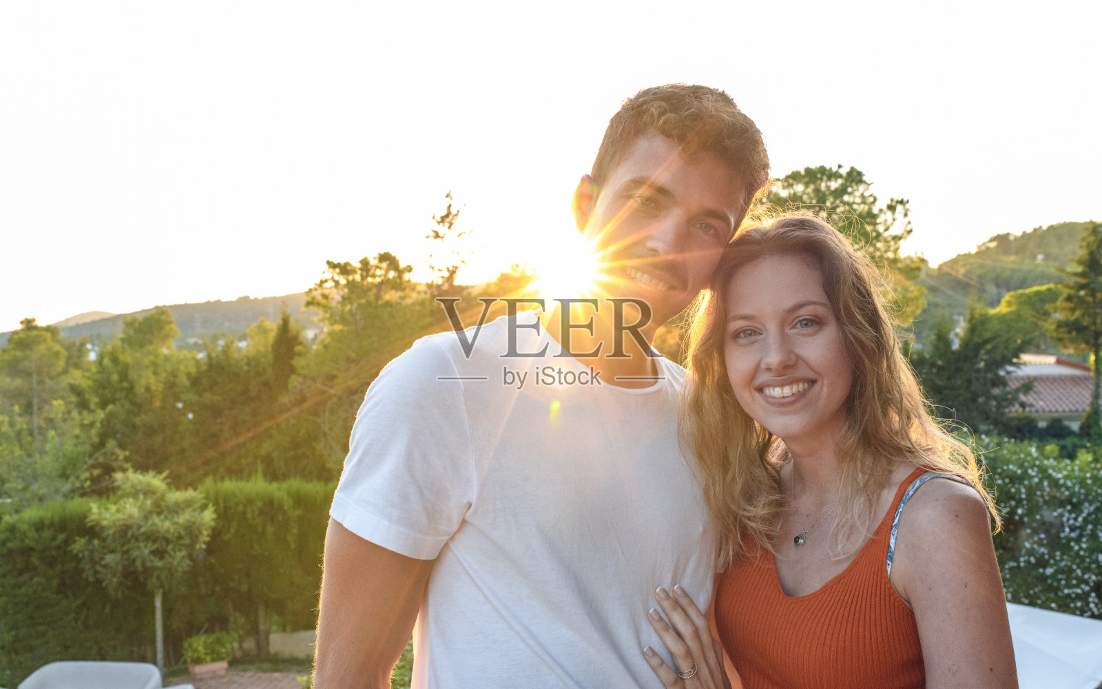 镜头光晕肖像快乐的年轻夫妇在傍晚照片摄影图片