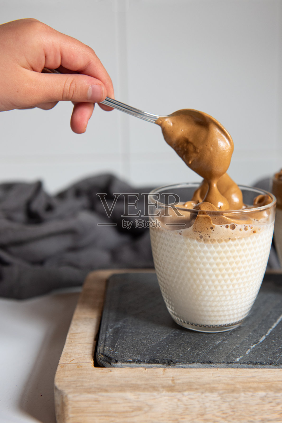Dalgona咖啡-速溶咖啡或浓缩咖啡粉,加糖和热水搅拌。照片摄影图片