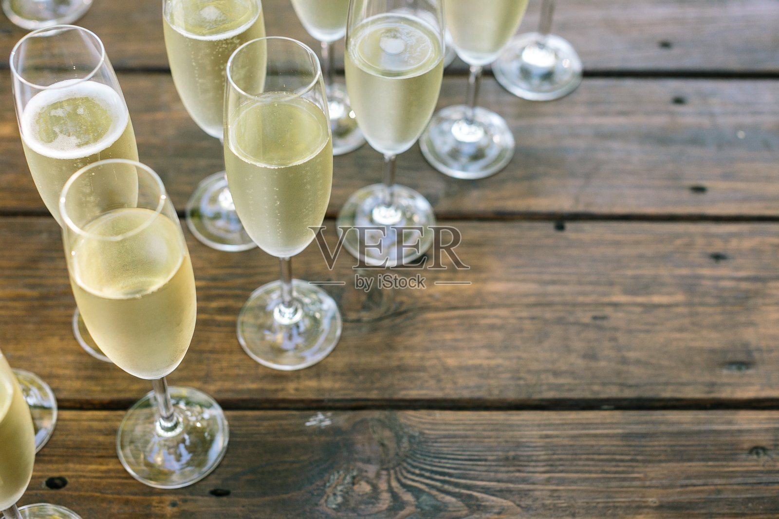 木桌上放着几杯冰凉的香槟,右边空着一块地方照片摄影图片