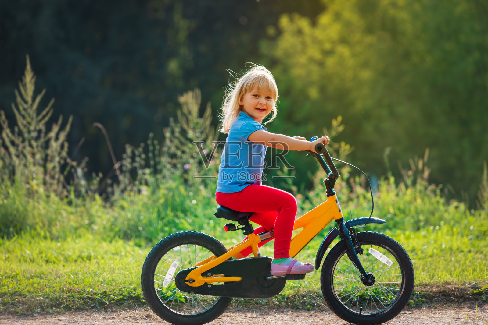 可爱快乐的小女孩在大自然中骑自行车照片摄影图片