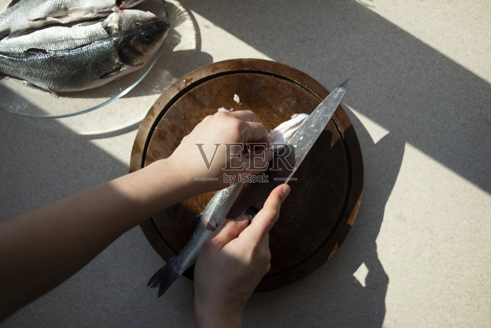 准备海鲈鱼的女人照片摄影图片