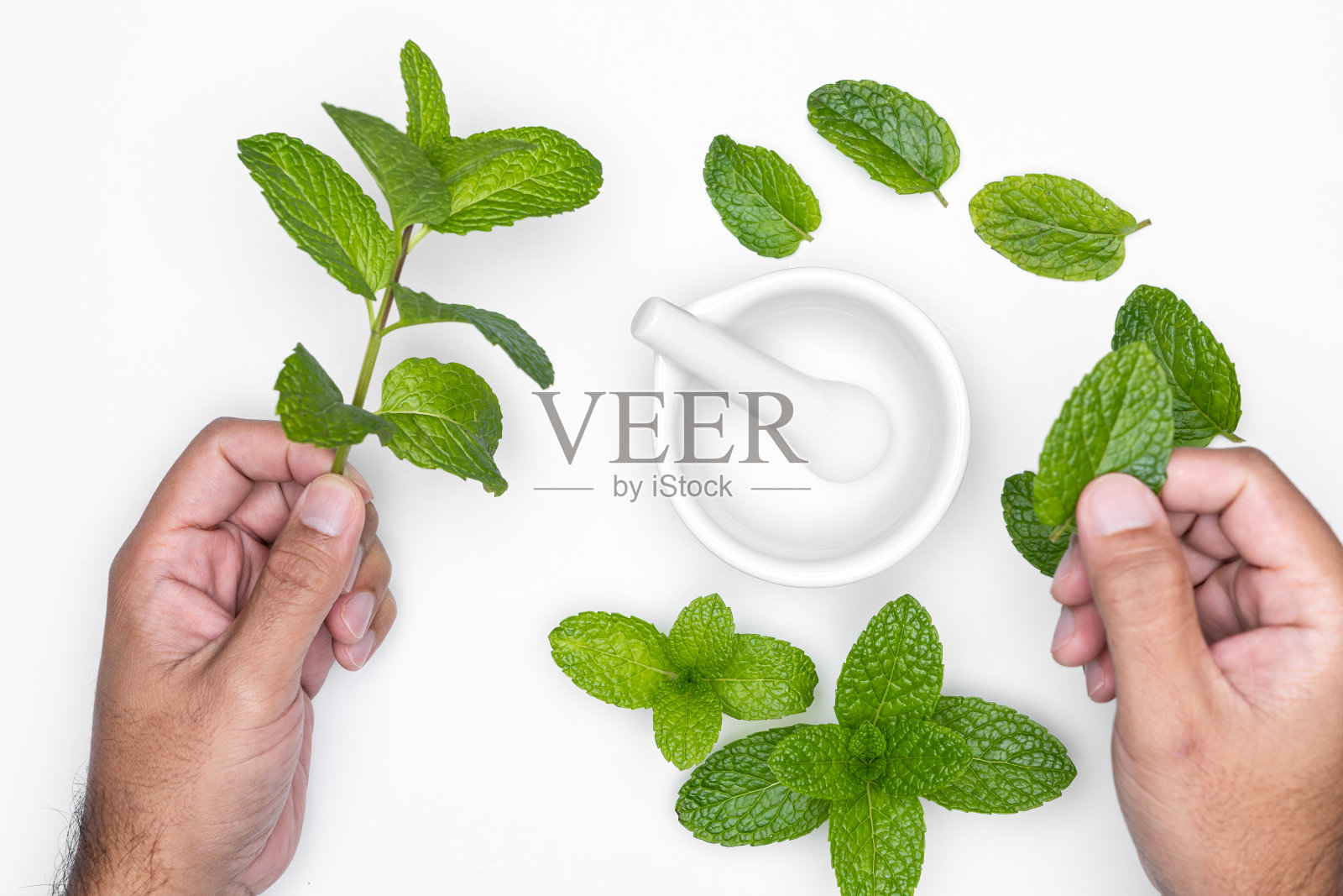 男子用研钵研磨和草药孤立在白色背景。复制空间。照片摄影图片