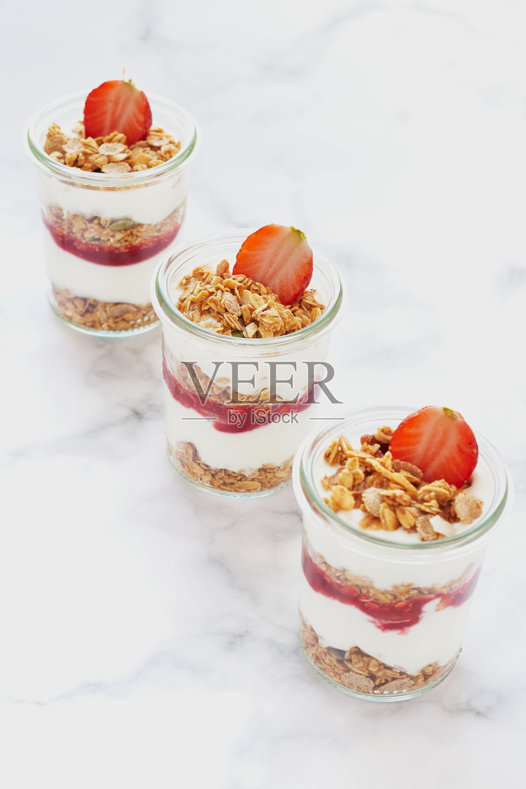 小罐的格兰诺拉麦片、酸奶草莓酱和新鲜草莓。照片摄影图片