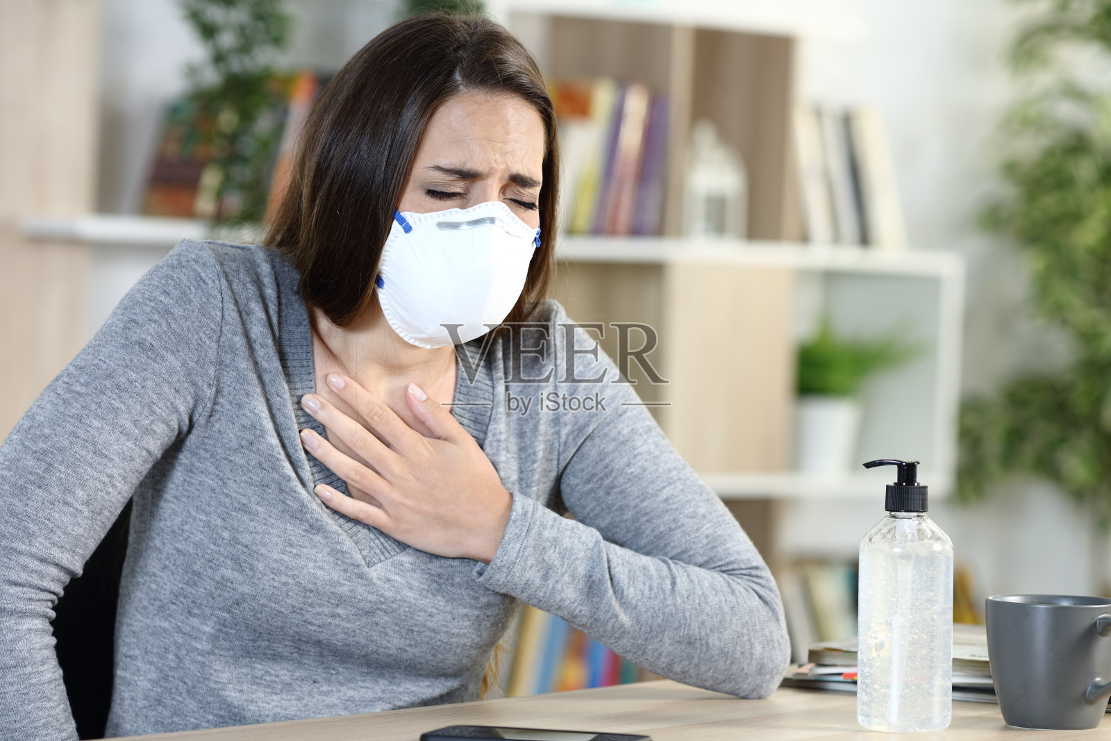 戴口罩在家因covid-19窒息的妇女照片摄影图片