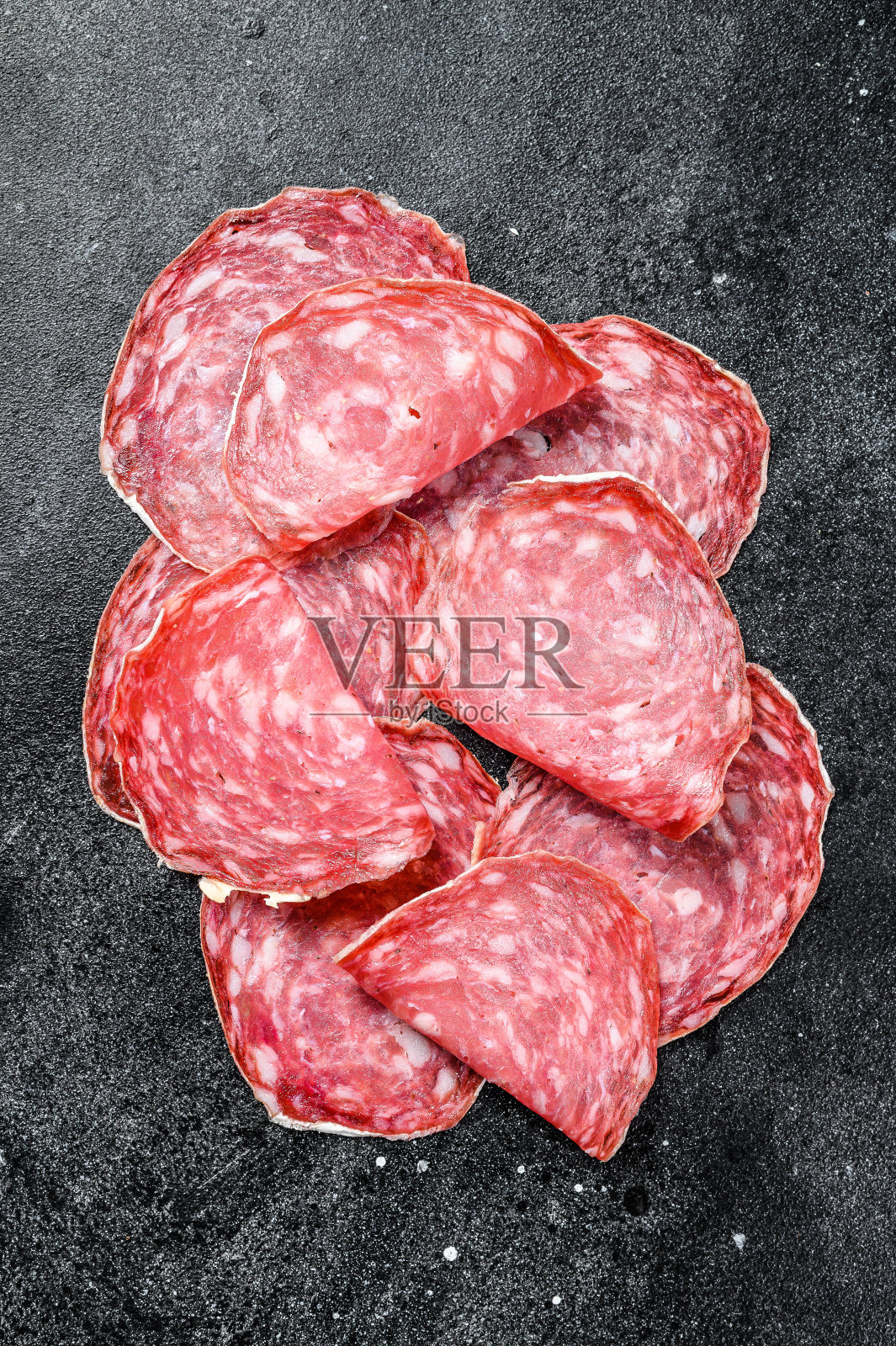 西班牙腊肠切片。黑色背景。俯视图照片摄影图片