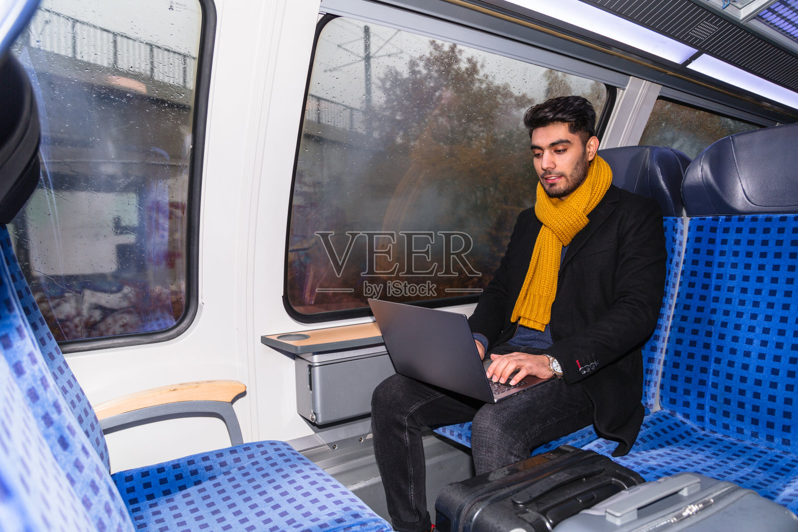 拉丁人一边坐火车一边用笔记本电脑工作照片摄影图片