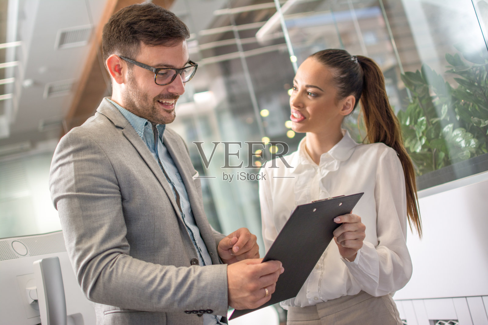 商务人士在办公室大厅举行愉快的非正式会议。照片摄影图片