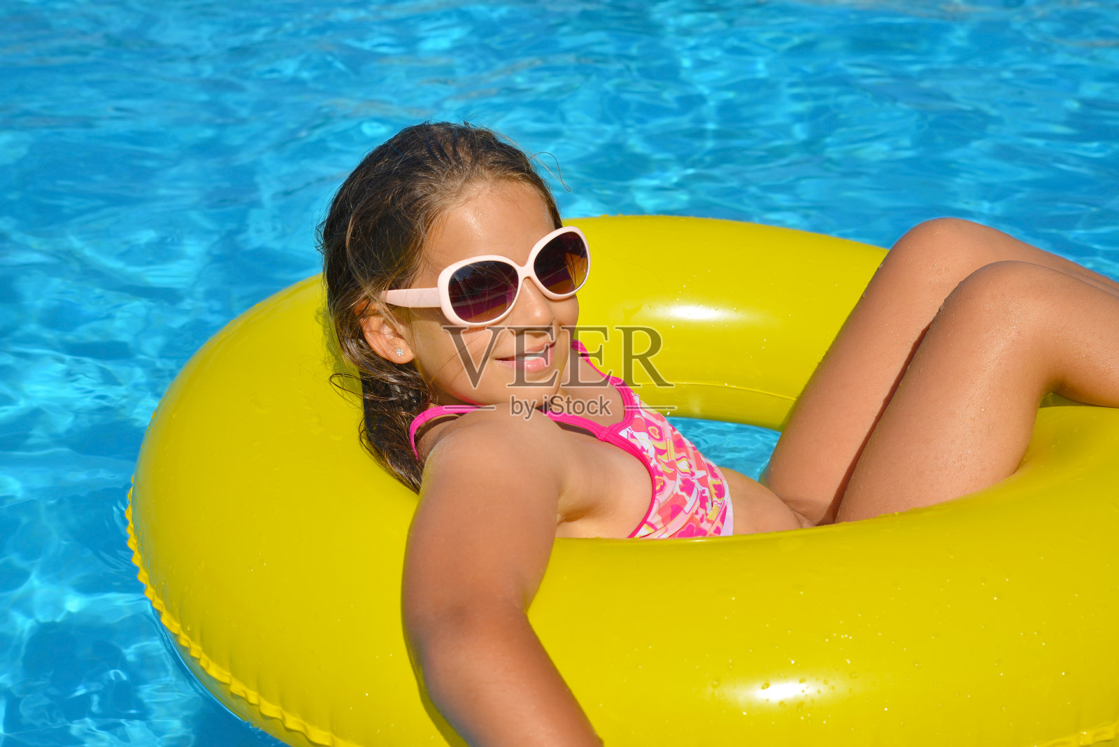 一个在游泳池里放松的可爱女孩照片摄影图片