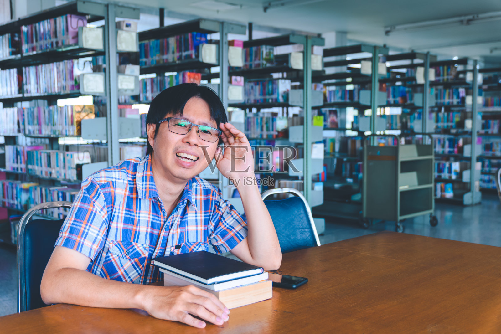 无聊的亚洲学生在图书馆看书照片摄影图片
