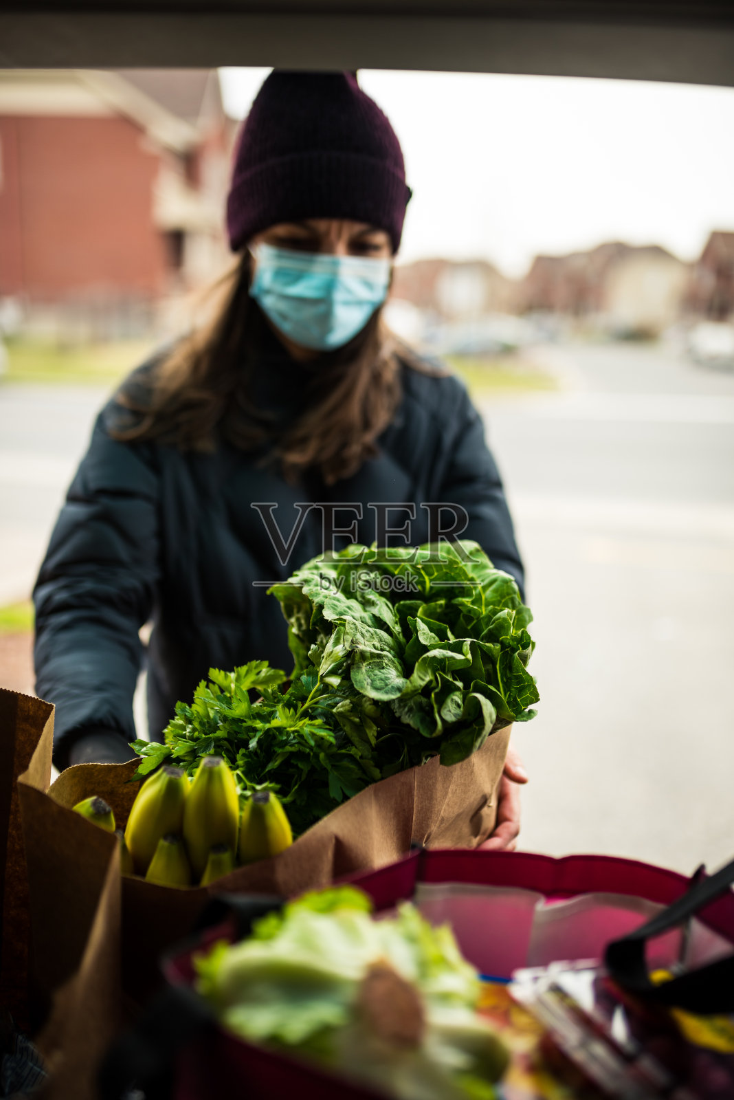 成熟的女人从汽车后备箱里卸下杂货照片摄影图片