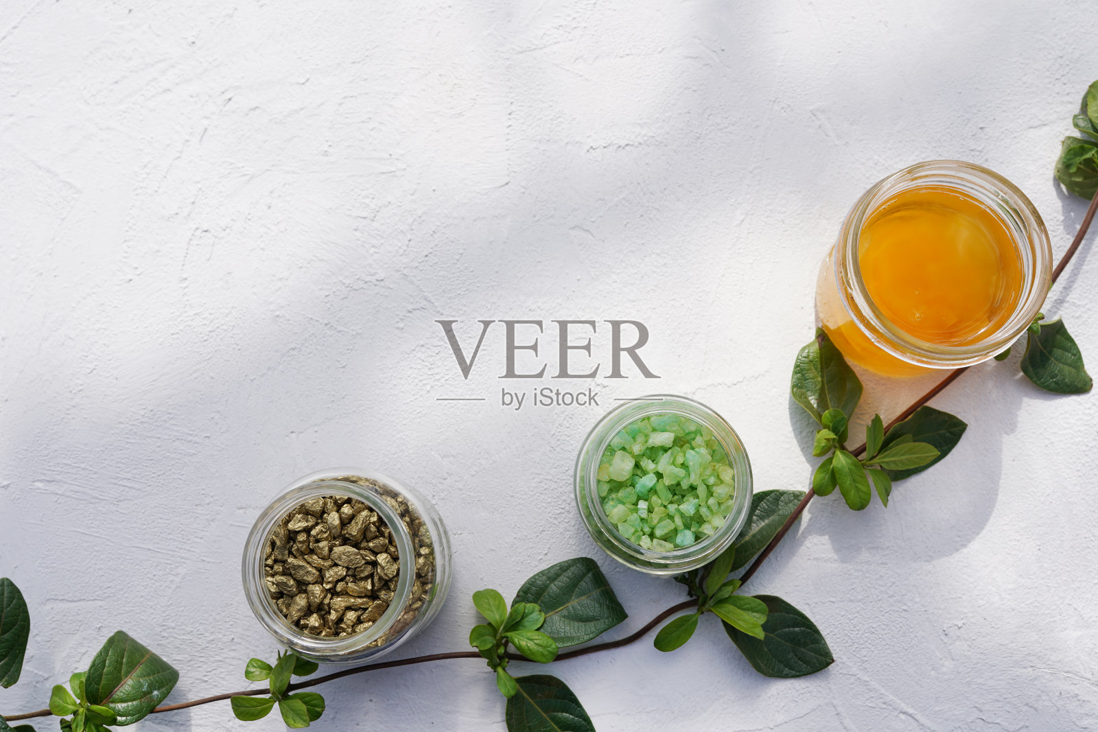 女性皮肤和身体护理化妆品组盐与绿色植物纹理混凝土背景。照片摄影图片