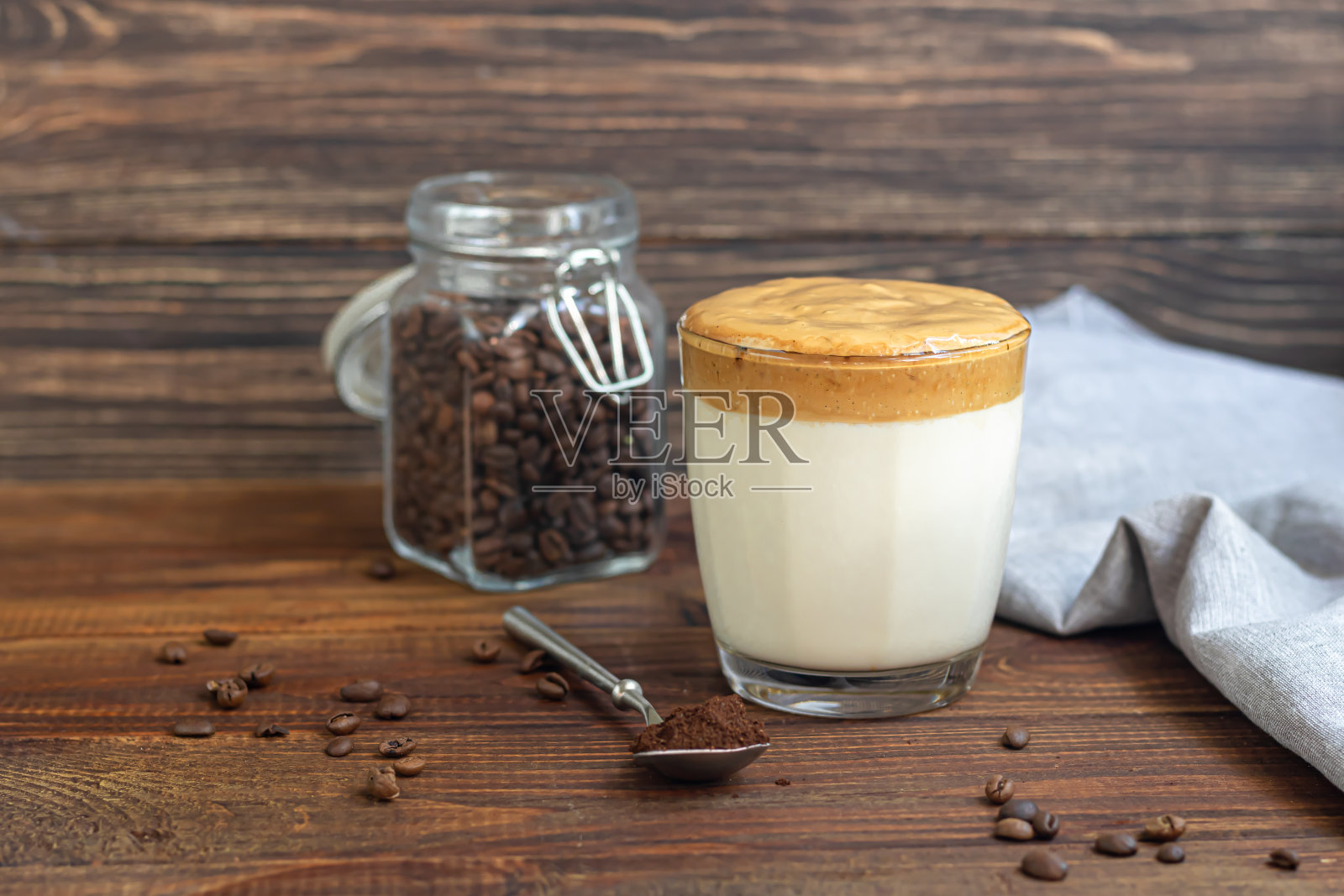 达尔戈纳咖啡是一种时尚的韩国冷饮。美味,芳香的咖啡,牛奶和糖,在一个木制的背景玻璃。照片摄影图片