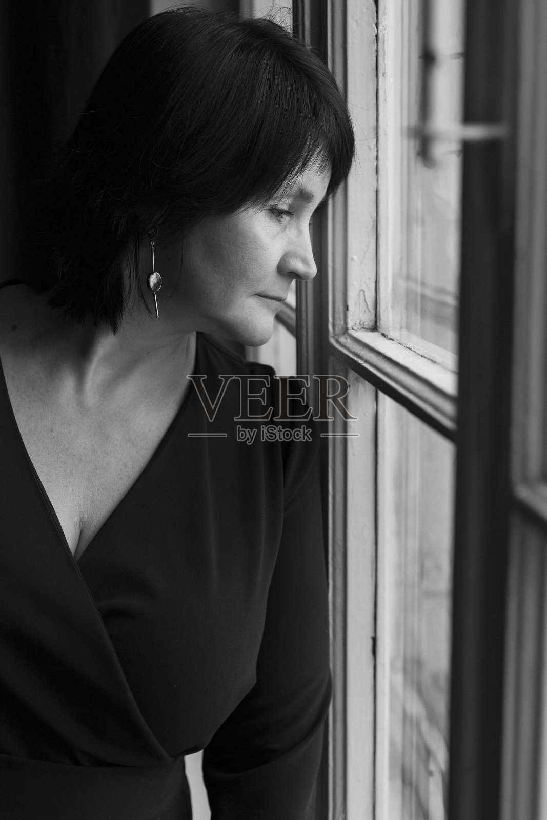 窗边悲伤成年孤独女性的肖像照片摄影图片