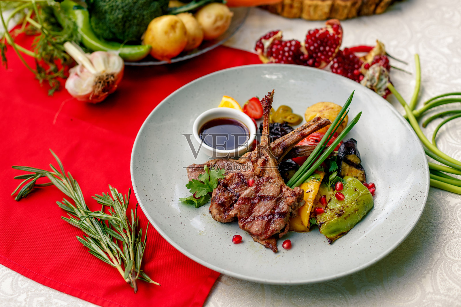 在白色盘子上烤肉、蔬菜和酱汁照片摄影图片