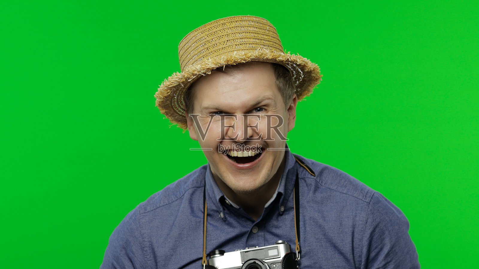 一个年轻的旅游摄影师的肖像笑得很大声。色度键照片摄影图片
