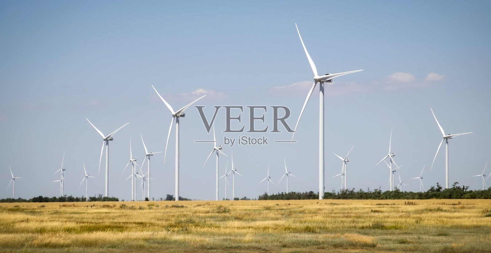 风力涡轮机和农田在夏季的一天。能源生产,清洁和可再生能源。照片摄影图片