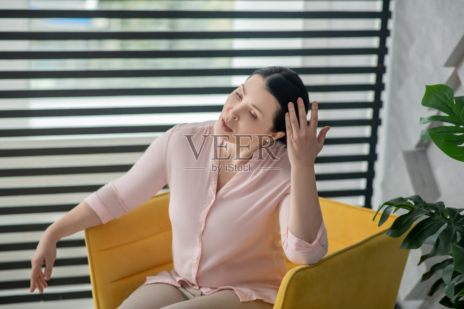 坐在黄色扶手椅上的漂亮女人照片摄影图片