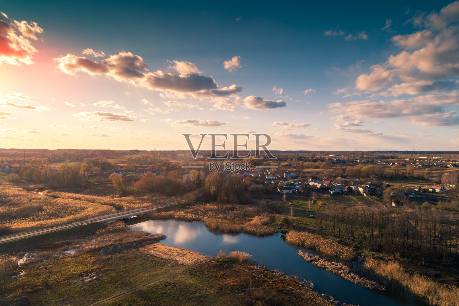 傍晚日落时鸟瞰乡村和小溪。美丽的乡村自然景观照片摄影图片