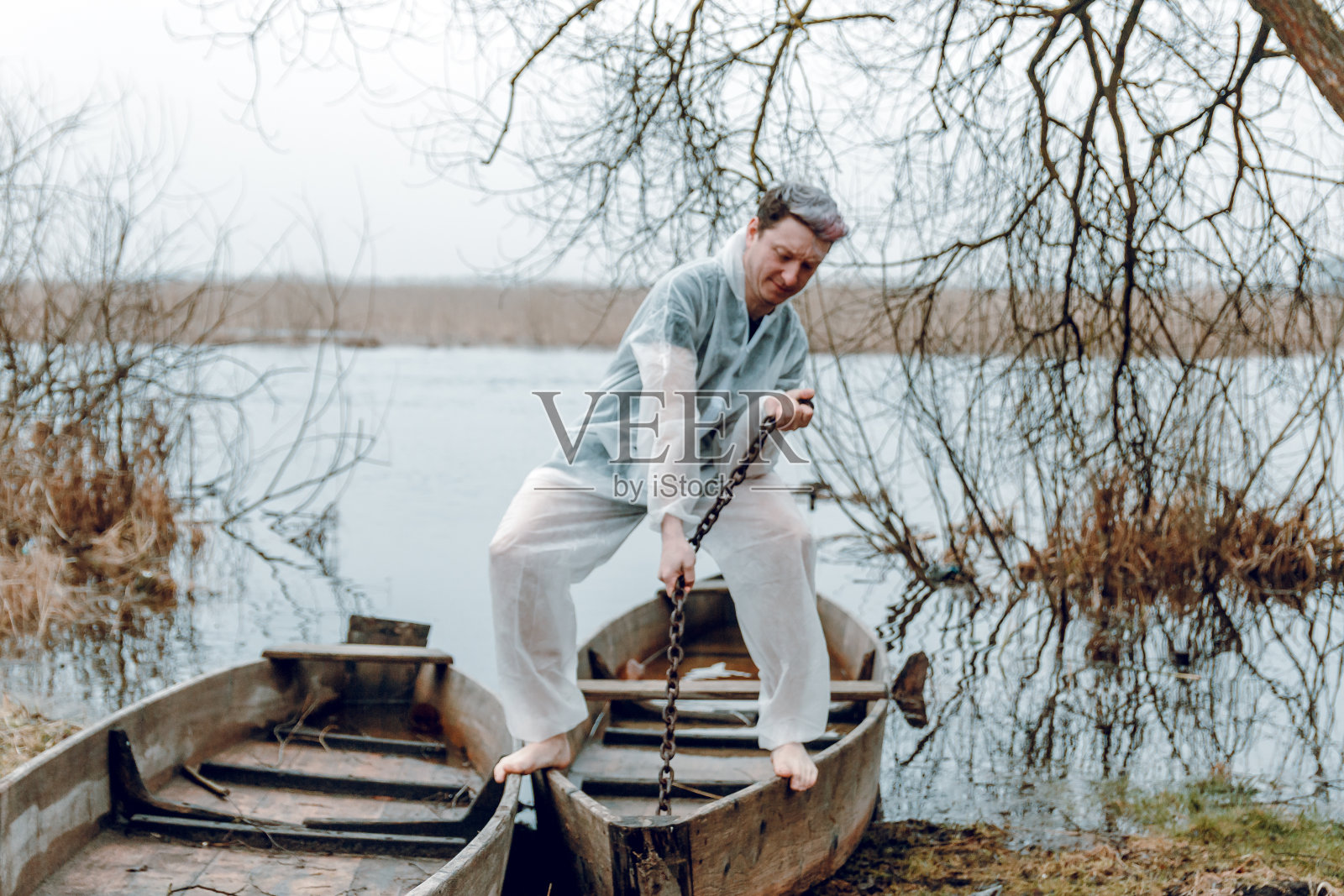 一个穿着白色防护服的男人,旁边有一个渡渡鸟,手里拿着链子。防病毒的防护服照片摄影图片