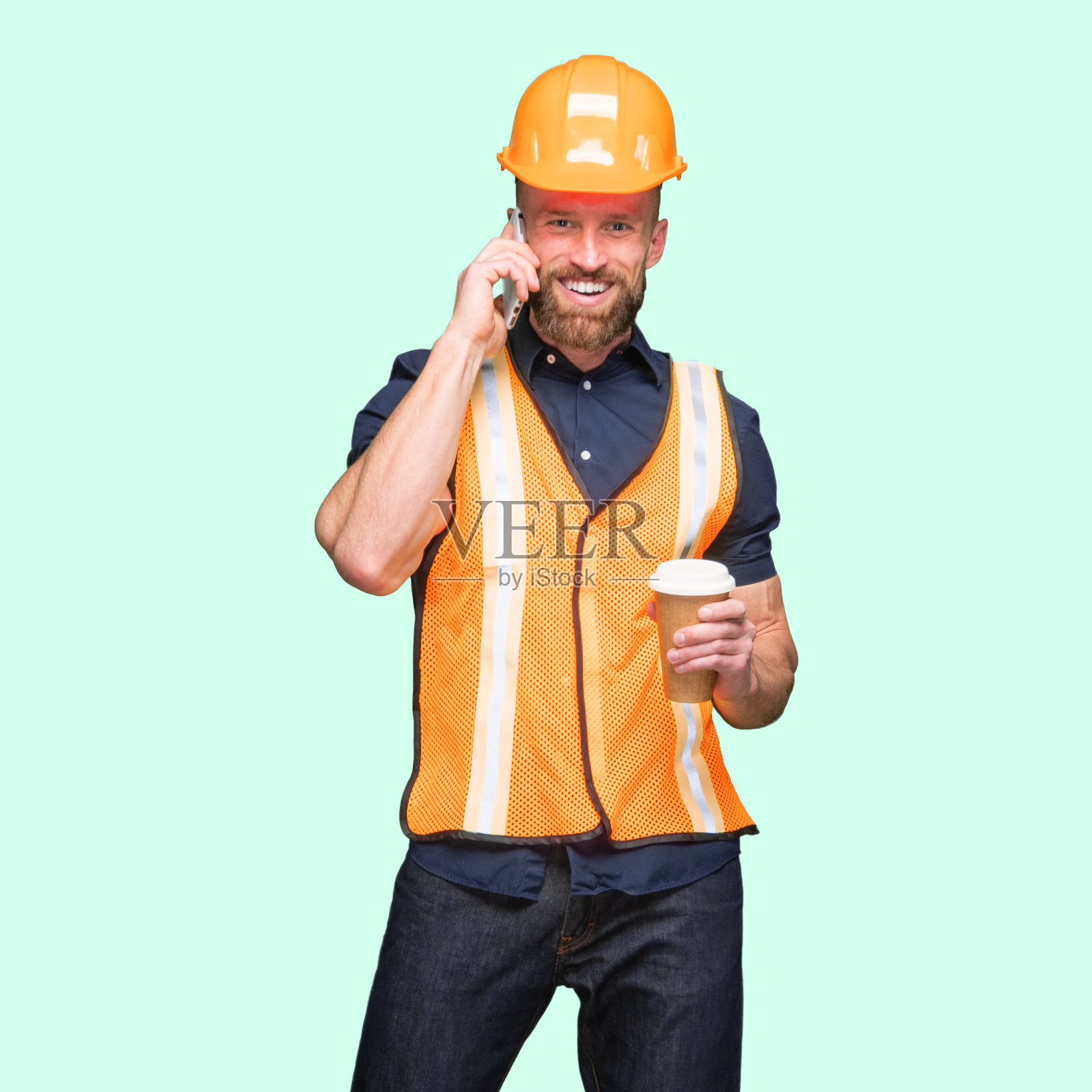 白人年轻男性站着,拿着咖啡杯,用手机照片摄影图片