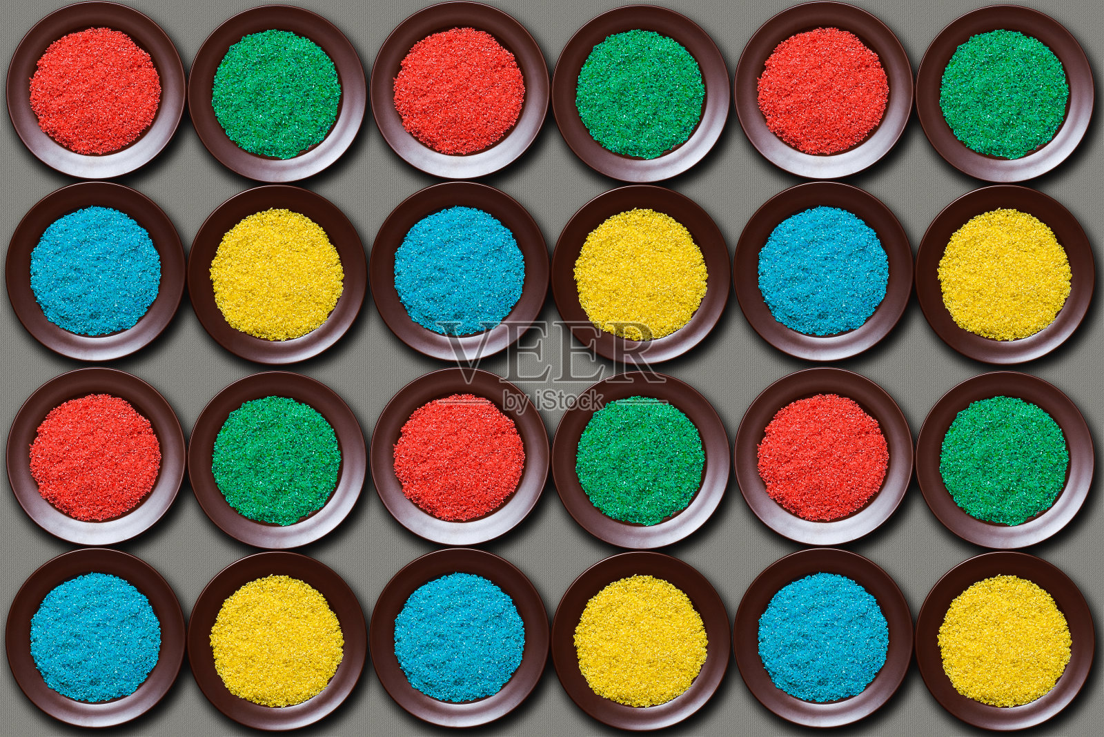 红的,绿的,蓝的,黄的米饭放在棕色的盘子里。照片摄影图片