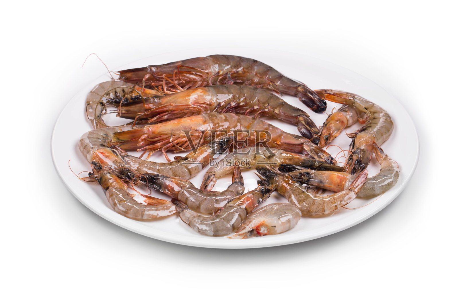 生虎虾放在盘子里。照片摄影图片