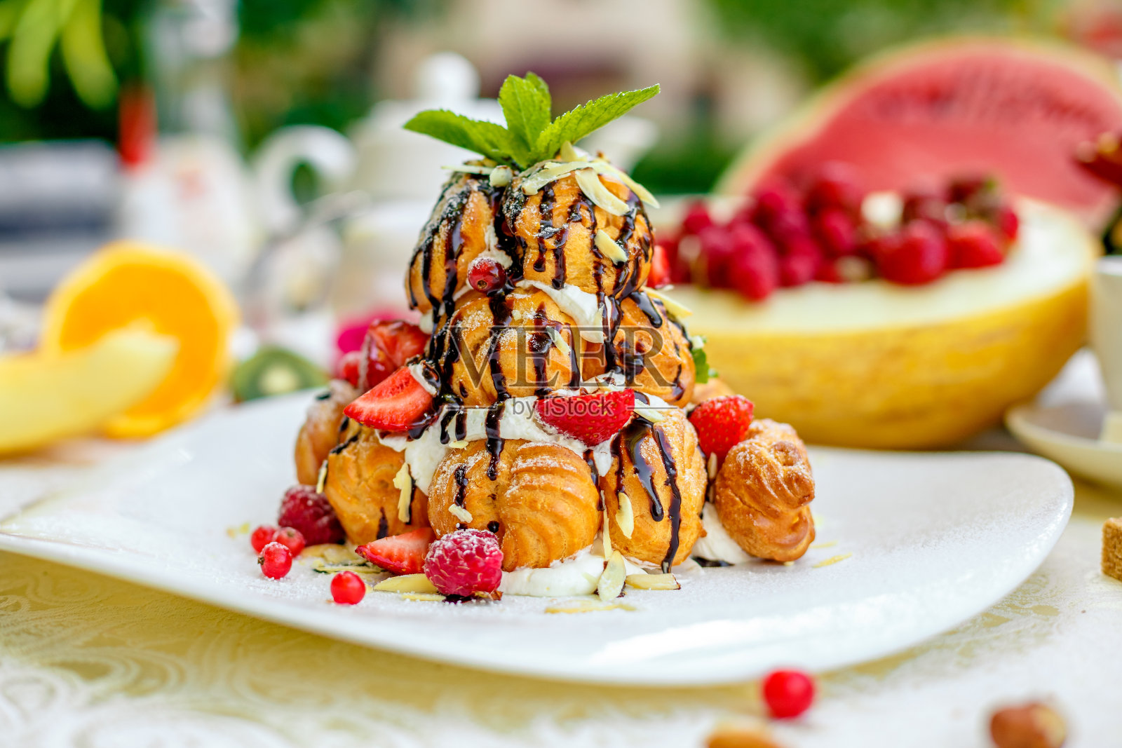 Krekembush -一种优雅的法国profiterole蛋糕,上面有巧克力和坚果照片摄影图片