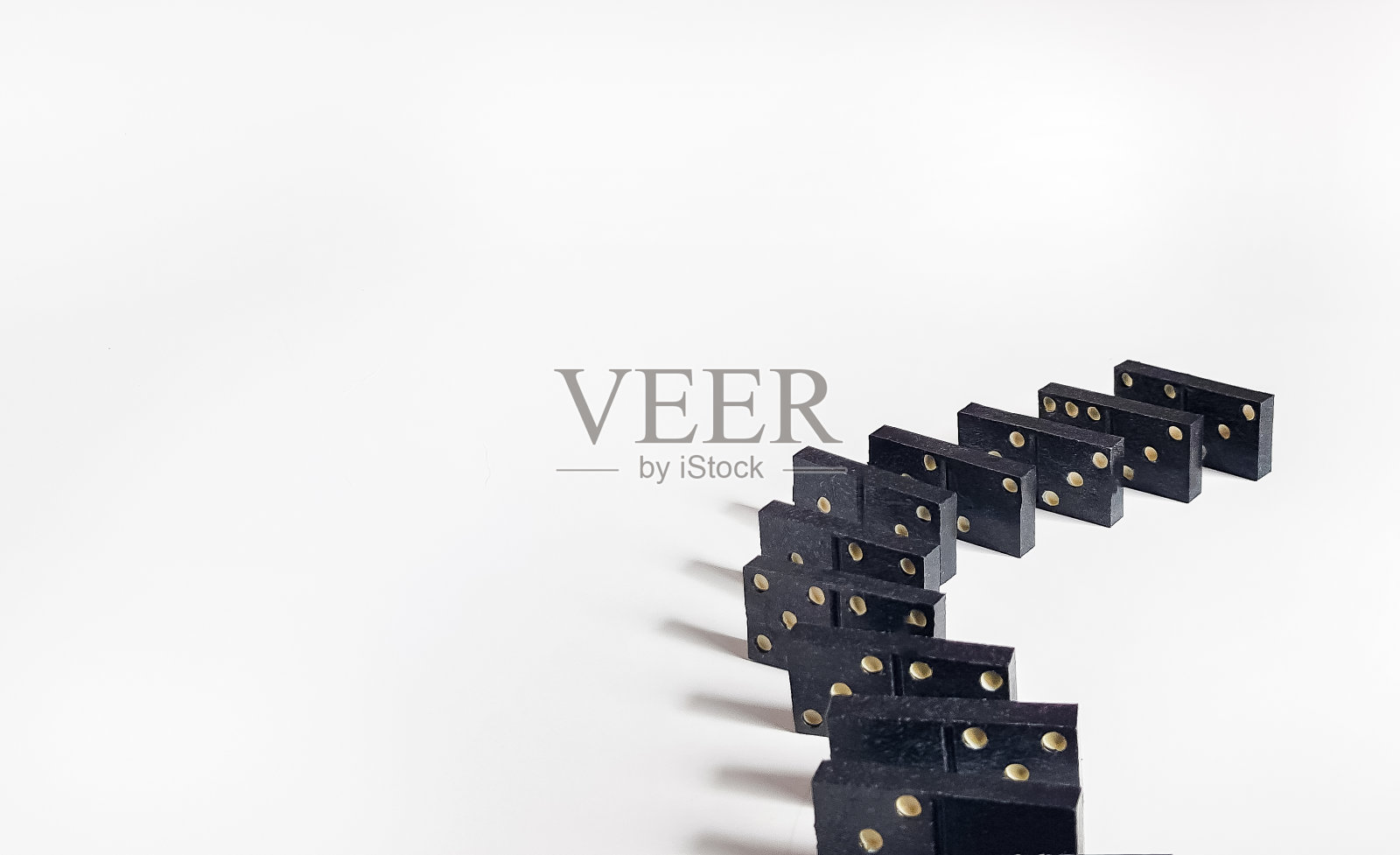 黑色多米诺在白色背景上的一条线与阴影和小自由度照片摄影图片