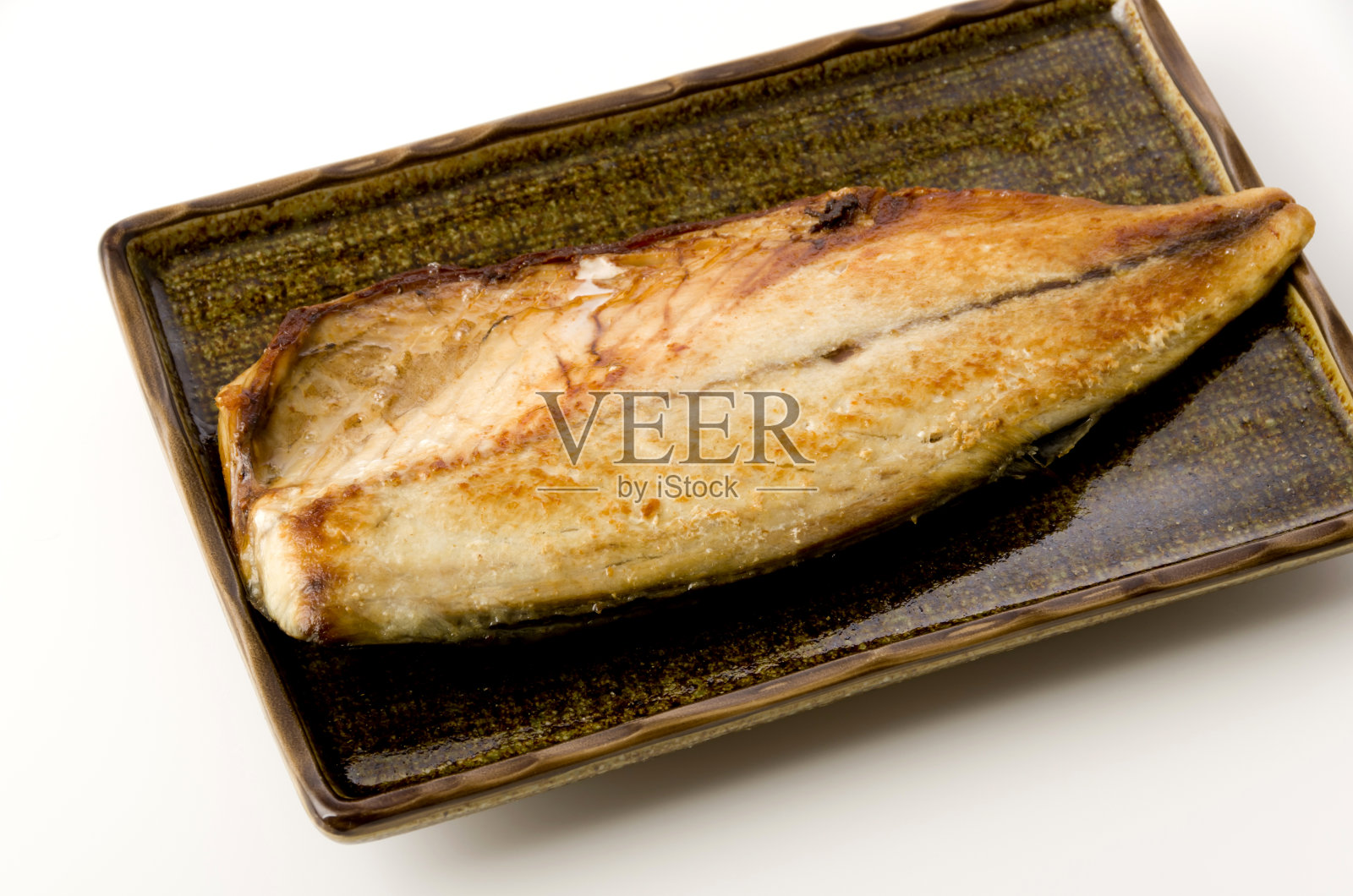烤鲭鱼(沙巴)在一个方形盘子上,在白色的背景照片摄影图片