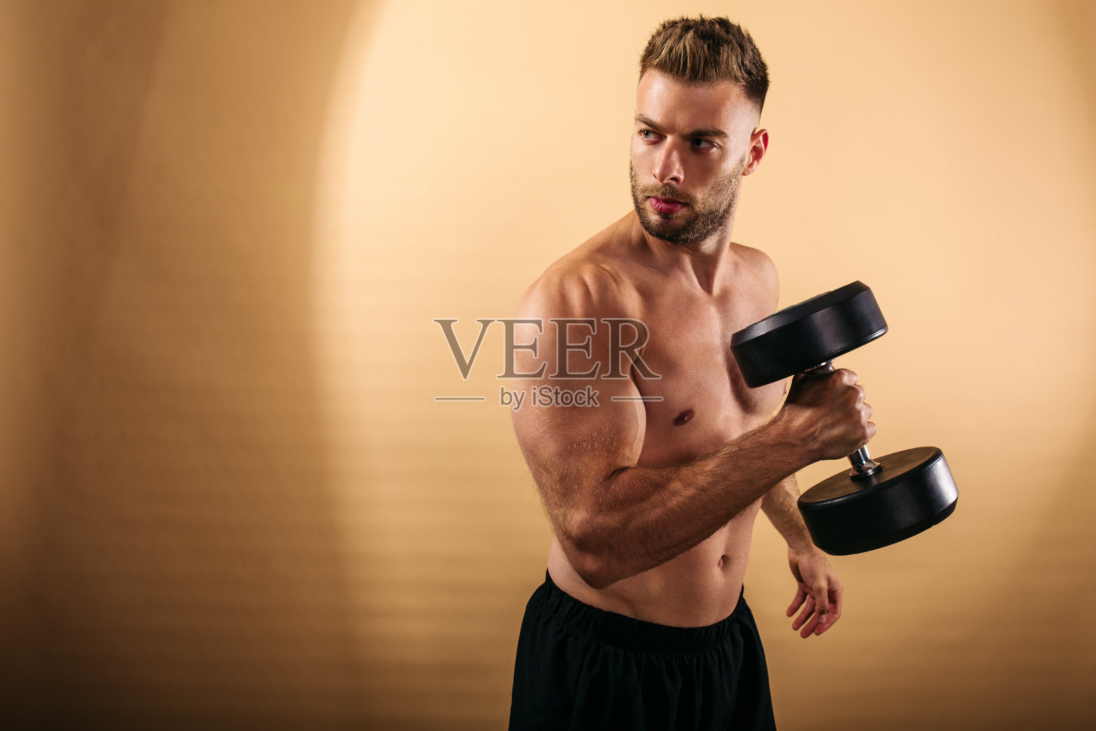 年轻的肌肉男在工作室里锻炼照片摄影图片