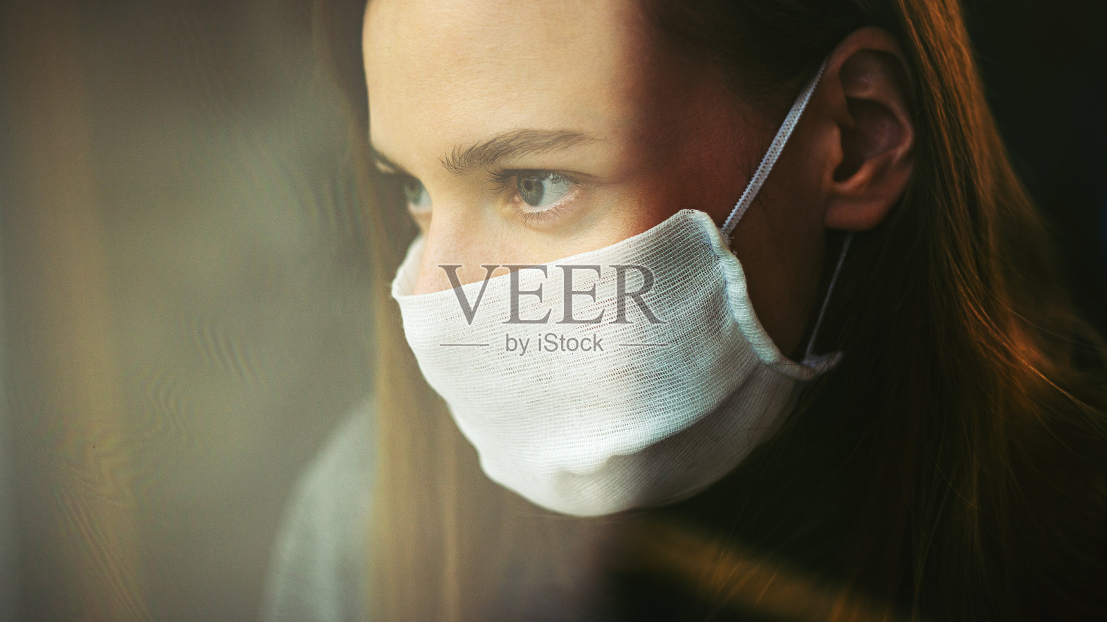 一个戴着纱罩的女人向窗外望去照片摄影图片