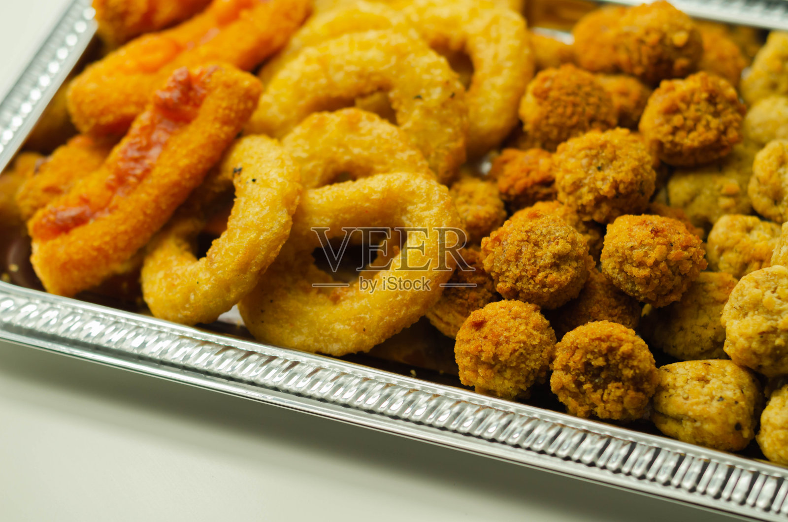 银盘子里放着南方炸鸡、烤鸡、洋葱圈和马苏里拉奶酪条照片摄影图片