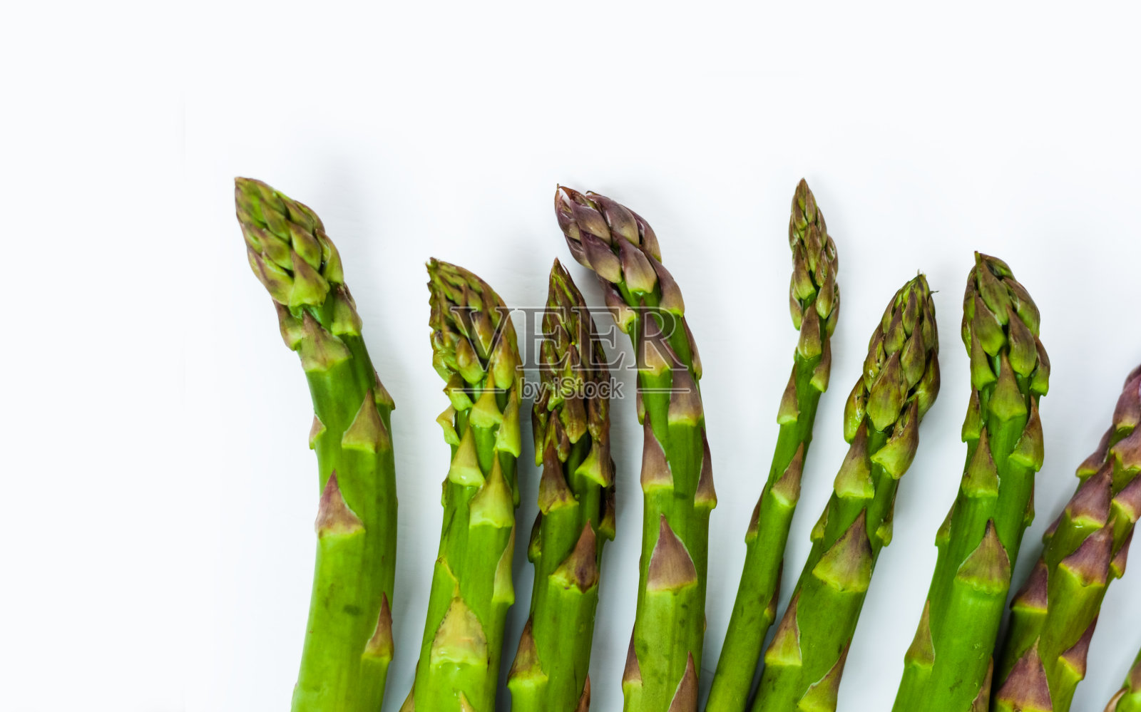 一束新鲜的生芦笋在白色的背景下,素食的概念。绿草雀稗,蔬菜的食物照片摄影图片