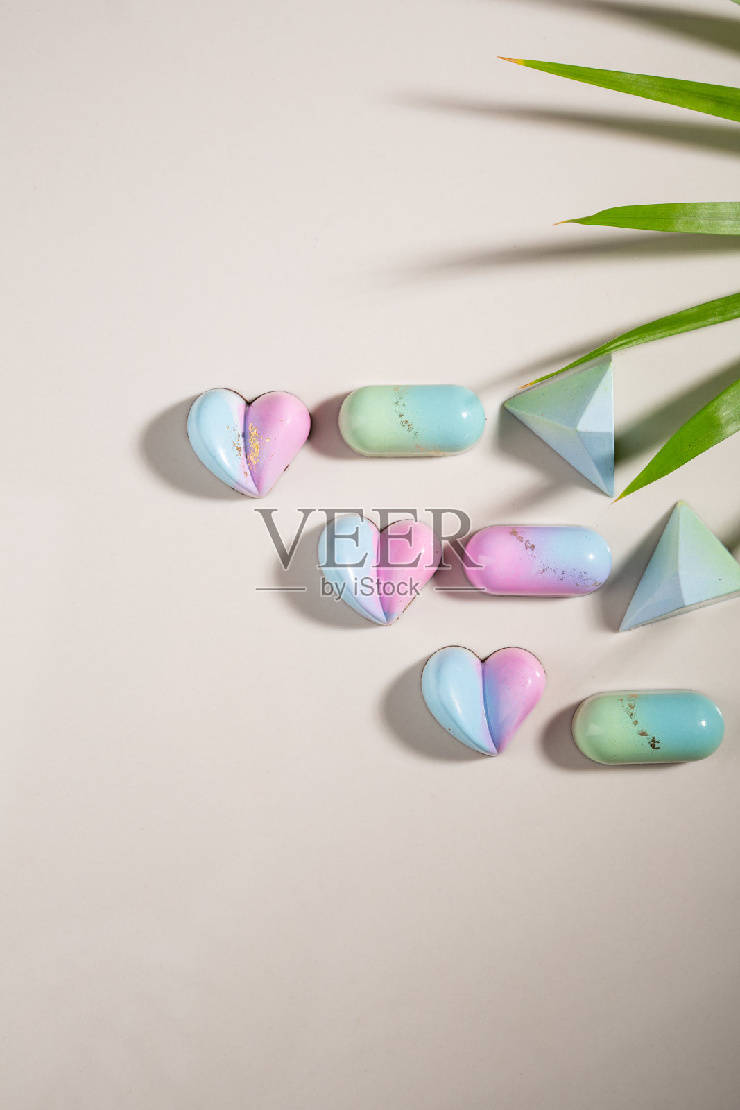 现代巧克力糖果,柔和的颜色和植物在轻石表面照片摄影图片