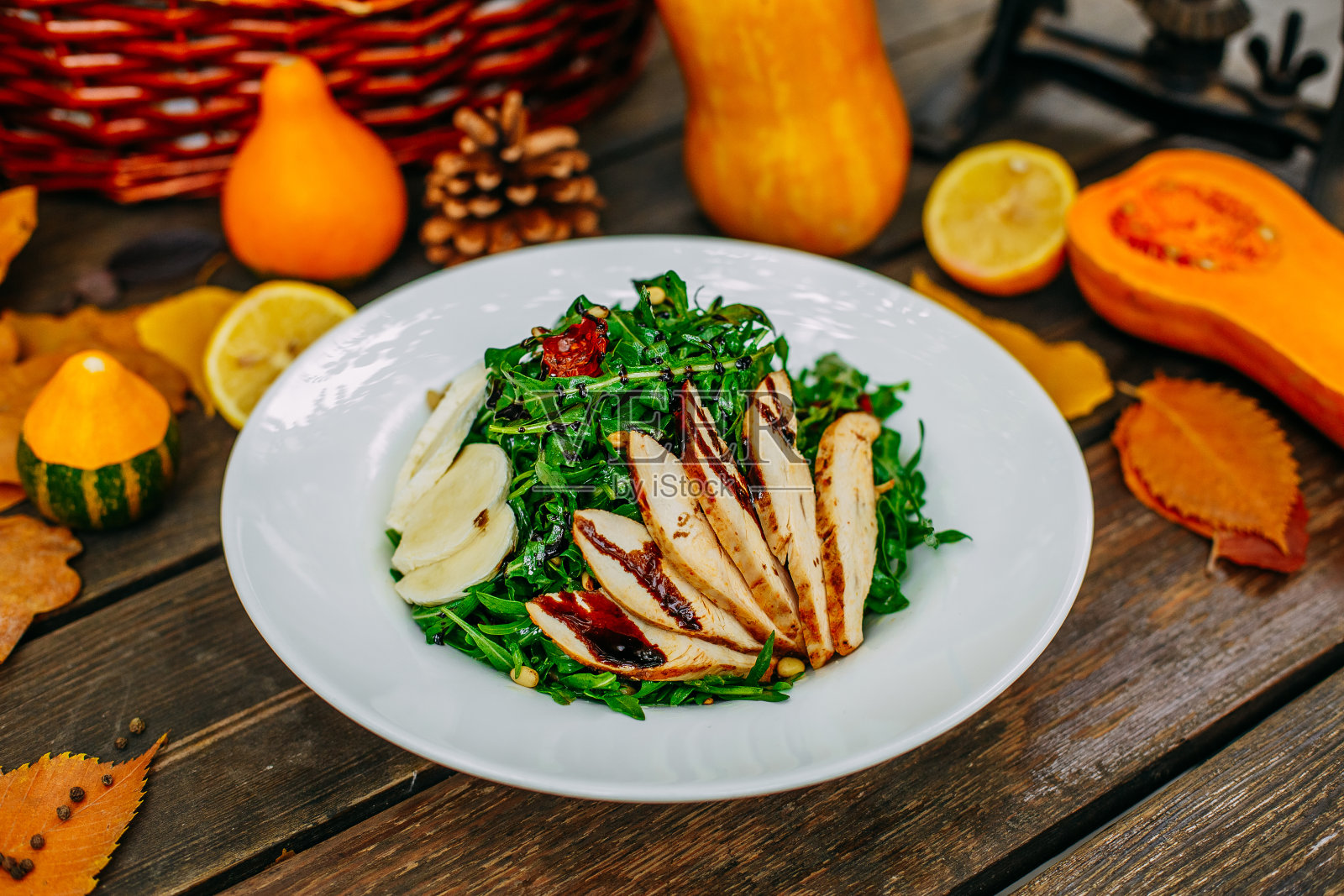 秋季餐桌上的南瓜。感恩节晚餐。鸡胸肉,奶酪和芝麻菜的沙拉照片摄影图片