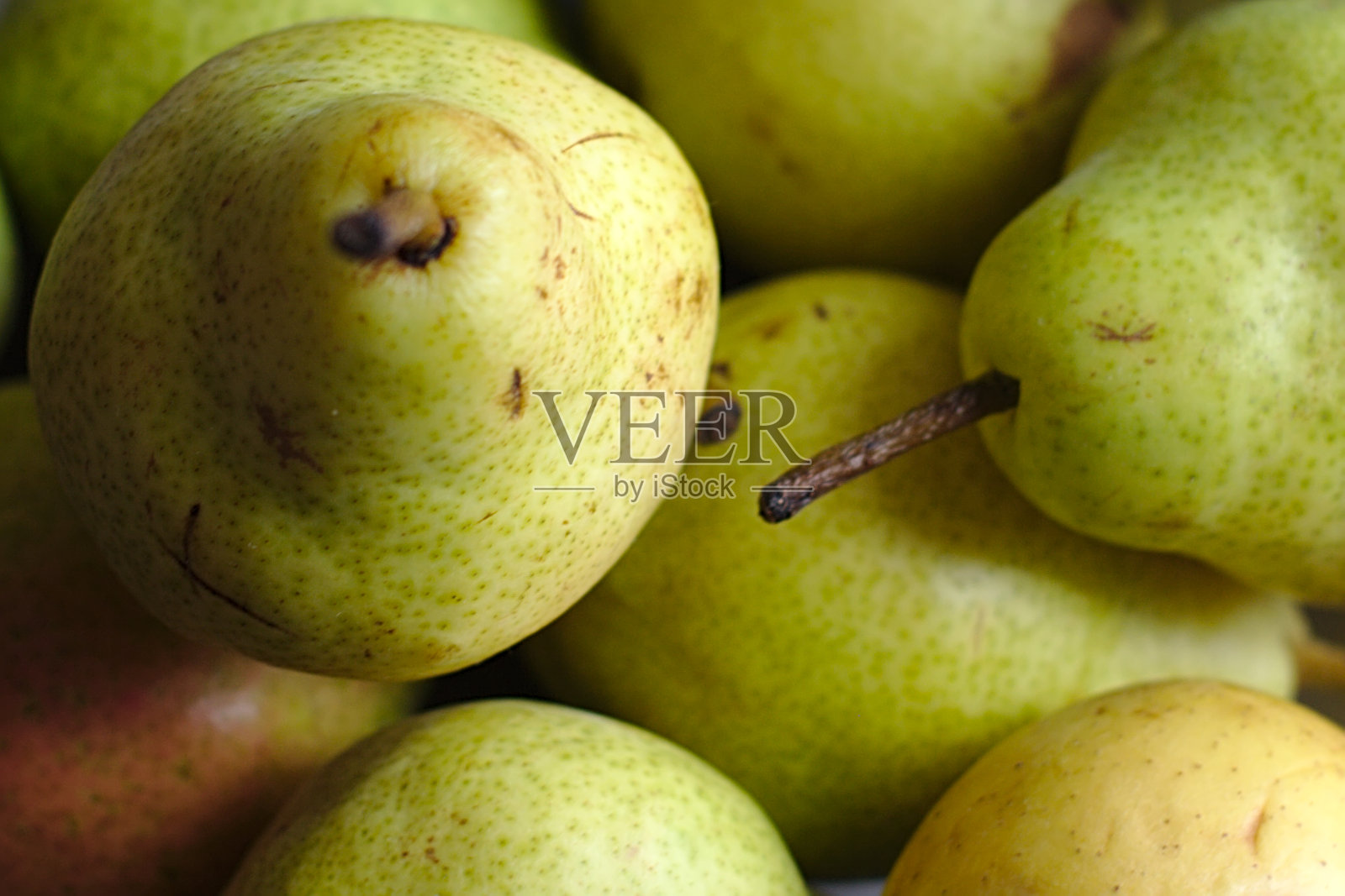 几个绿色的梨堆放在一个盘子里照片摄影图片