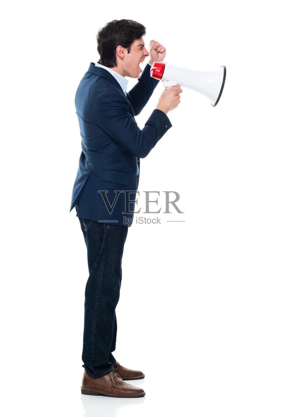 白人年轻男性商人站在白色背景下,穿着漂亮的休闲装,手持扩音器照片摄影图片