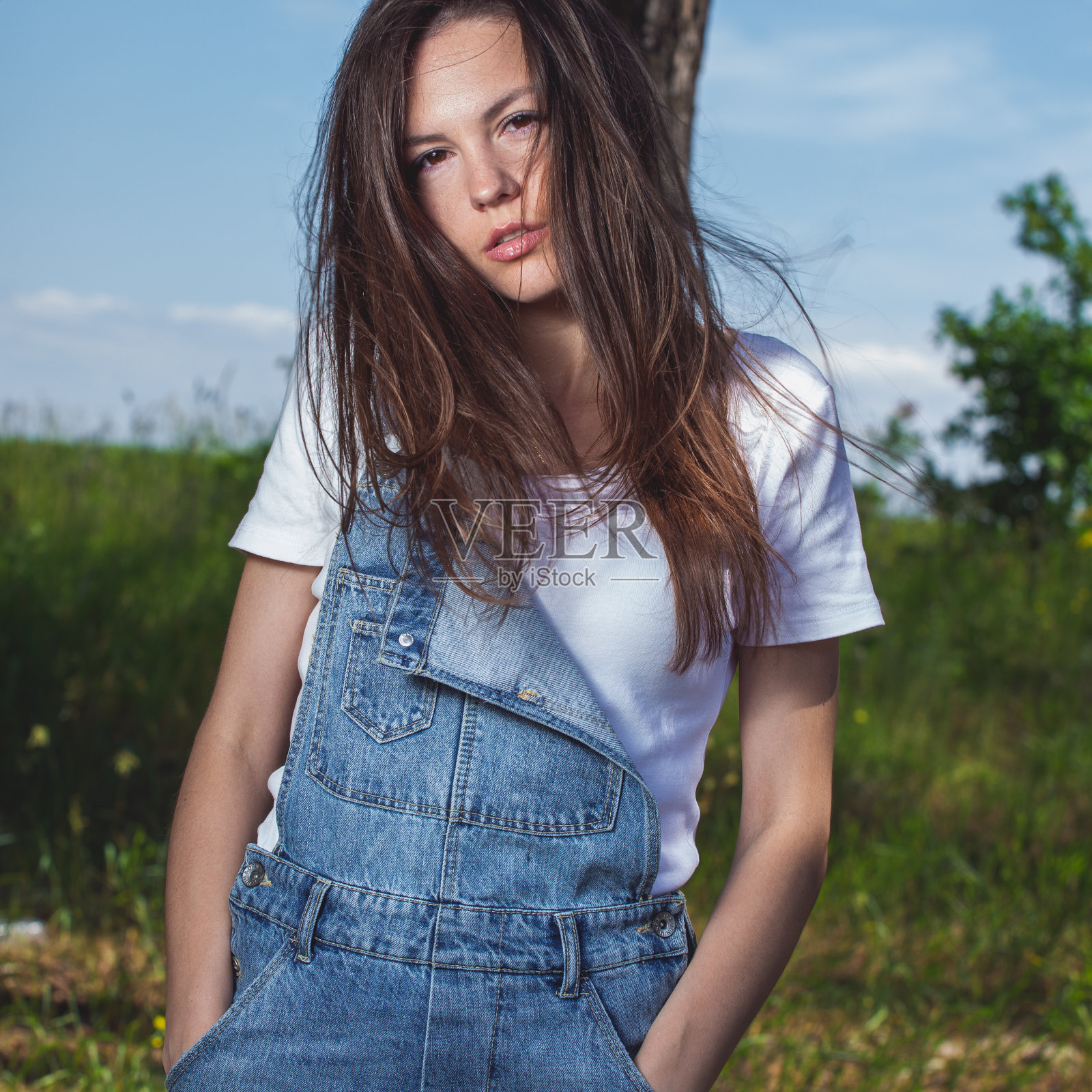 森林里穿着白色t恤和牛仔裤的美女照片摄影图片