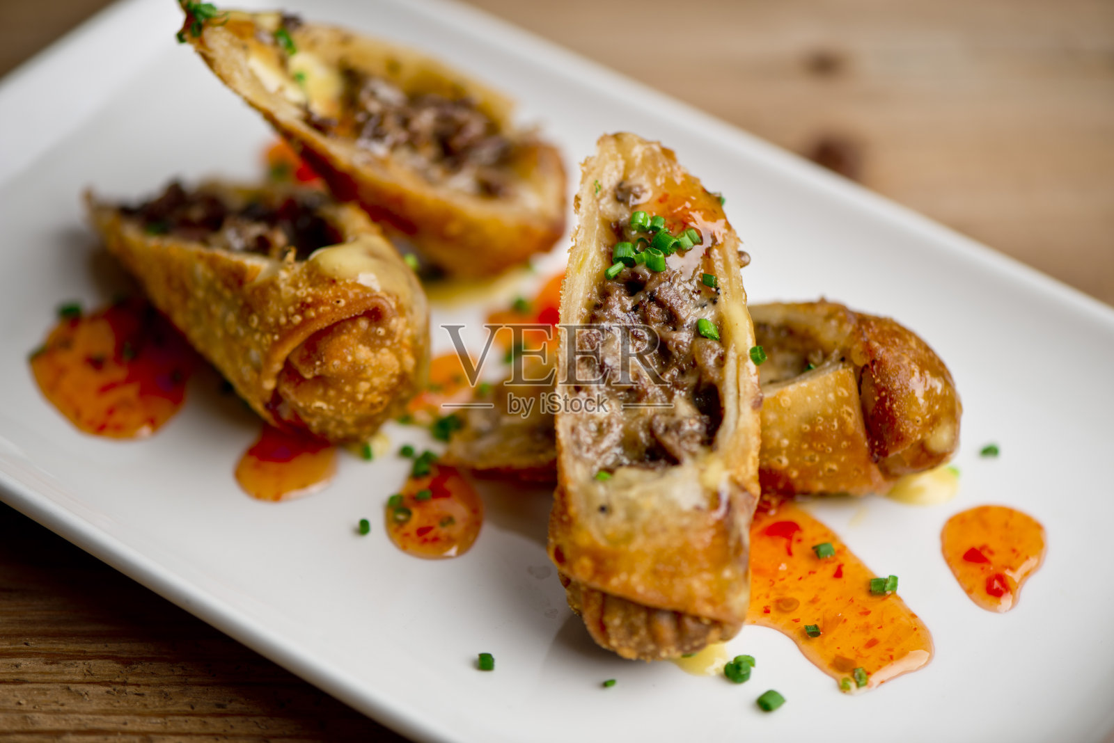 蛋卷牛排餐厅的风格。煎至半熟的蛋卷,配上酸甜辣酱和葱花作装饰。经典美国牛排餐厅的最爱。照片摄影图片