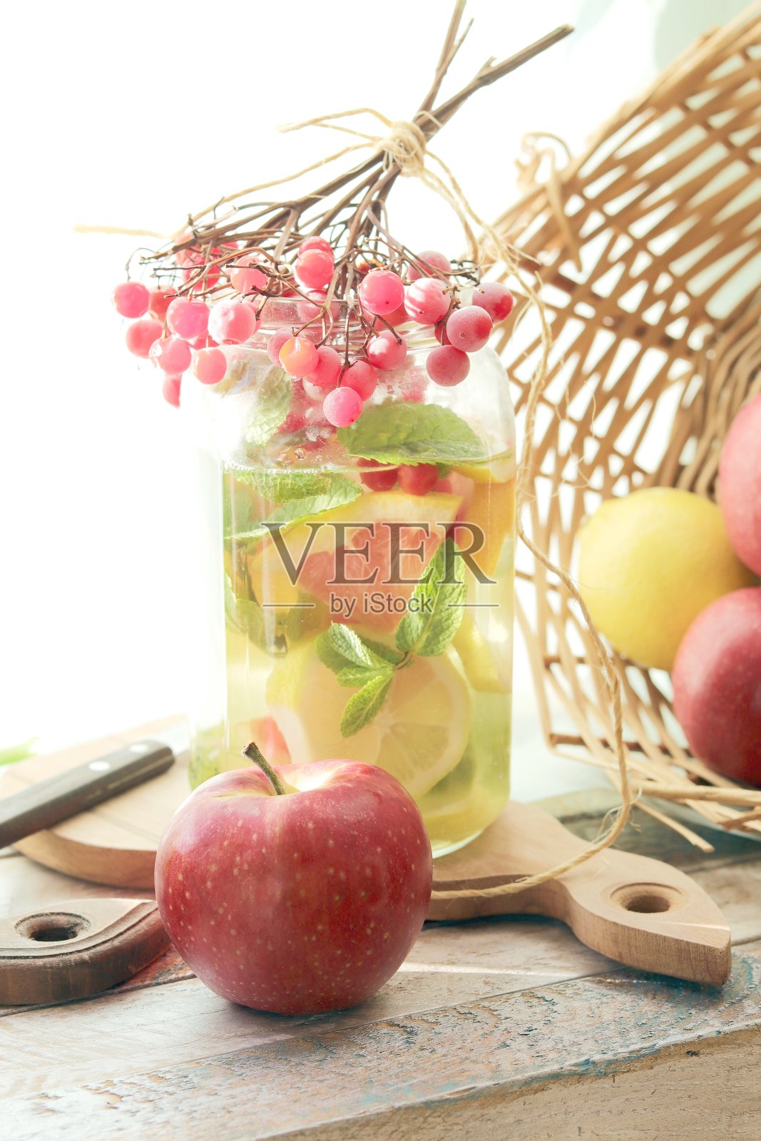 自制的冰沙由有机水果和浆果,薄荷叶在玻璃容器放在木桌上照片摄影图片