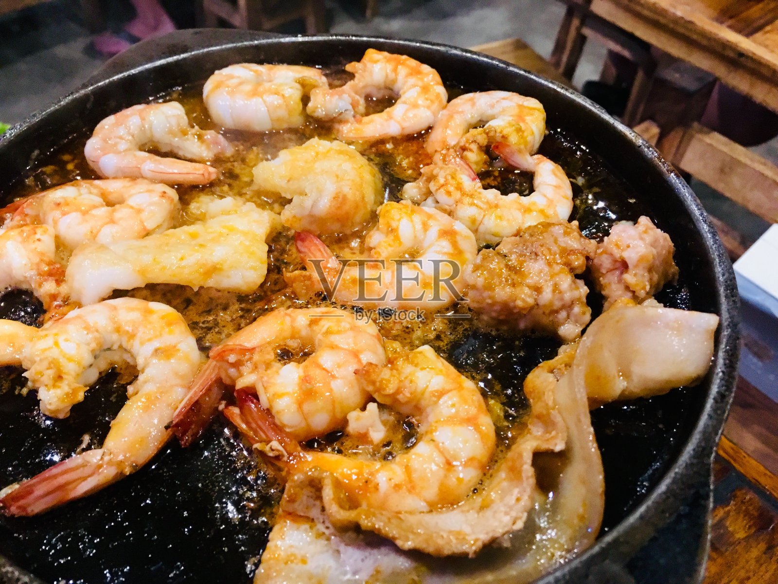 在热锅上烤的大虾和黄油。照片摄影图片