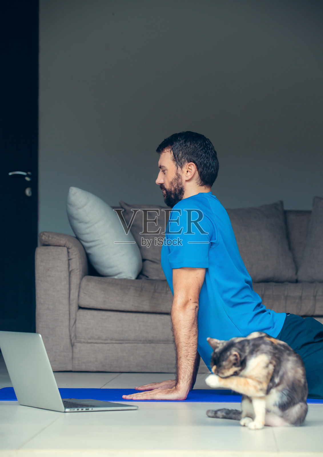 男人在运动前后在家伸展。健身训练,伸展运动,在线锻炼。2019冠状病毒病大流行期间在家的自我照顾照片摄影图片