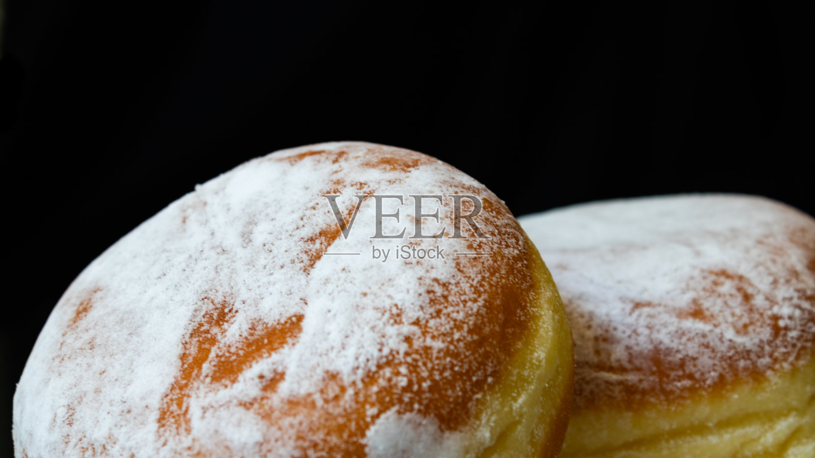 黑色背景上有几个加糖的甜甜圈。孤立的甜甜圈在水平照片。照片摄影图片