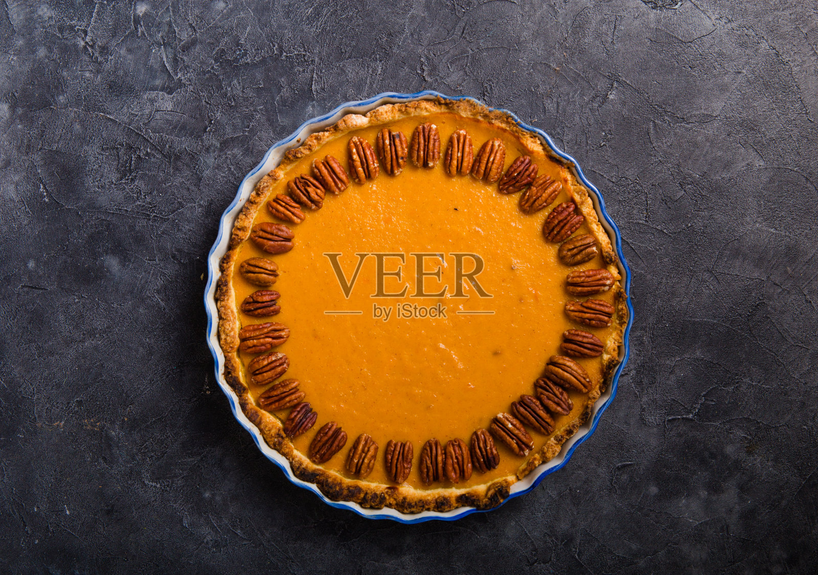 南瓜派和切片核桃和肉桂在混凝土背景,俯视图,复制空间。自制的感恩节秋季糕点照片摄影图片