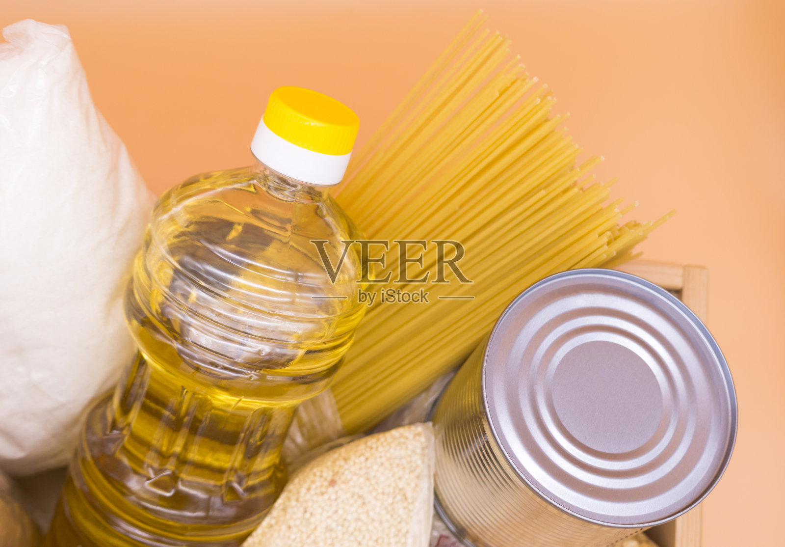 捐赠盒与食物:罐头食品,面食,豌豆,小米,糖,油,饼干在一个橙色的背景。前视图。食品库存检疫隔离期。照片摄影图片