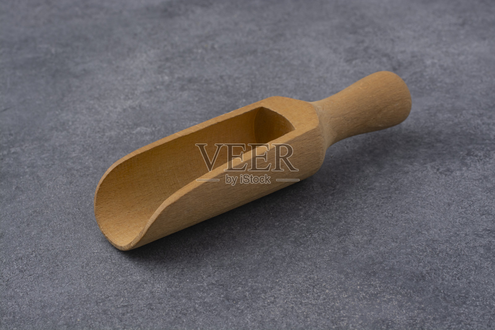 木制勺为大宗产品在灰色的背景。照片摄影图片