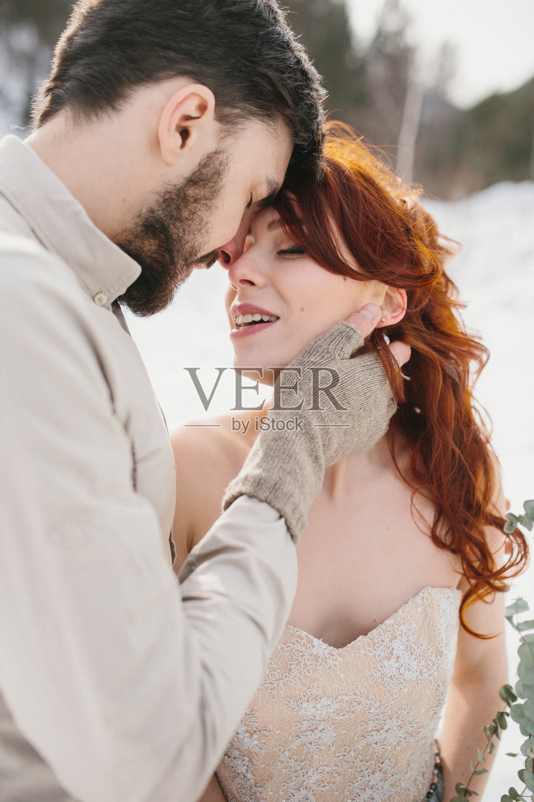 时髦的年轻美丽的夫妇新娘和新郎拥抱。背景冬天的山脉和森林照片摄影图片